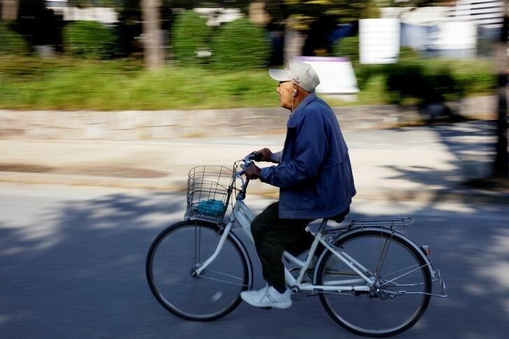 An elderly man rides his bicycle thorugh the grounds of Osaka Castle in Osaka, Japan October 26, 2017. REUTERS/Thomas White