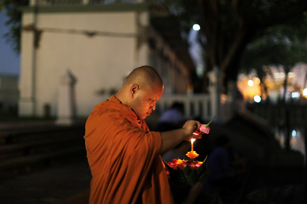 A Buddhist monk prays before casting krathongs into a pond in a public park during the Loy Krathong festival which is held as a symbolic apology to the goddess of the river in Bangkok, Thailand, November 22, 2018. REUTERS/Jorge Silva - RC1187A0D580
