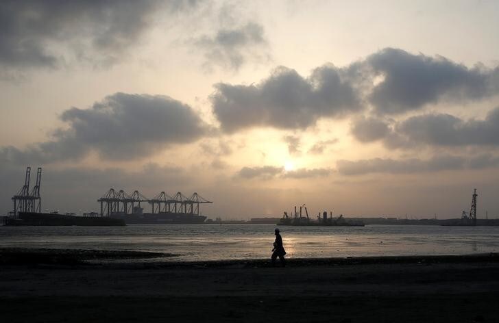 A man is silhouetted as he walks amid hot and humid weather at breakwater along port area in Karachi, Pakistan May 7, 2018. REUTERS/Akhtar Soomro