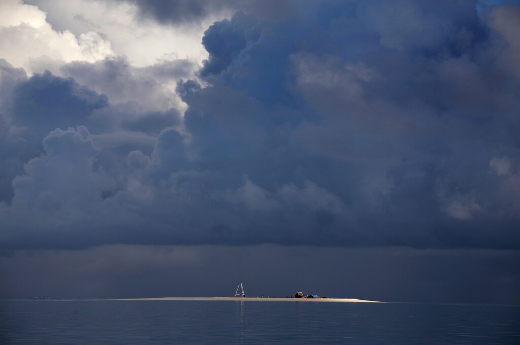 Storm clouds gather above the small huts and tower on Bikeman islet, located off South Tarawa in the central Pacific island nation of Kiribati May 25, 2013. The tower used to mark the centre of the islet, but shifting sand over the years has pushed the tower further into the lagoon. Kiribati consists of a chain of 33 atolls and islands that stand just metres above sea level, spread over a huge expanse of otherwise empty ocean. With surrounding sea levels rising, Kiribati President Anote Tong has predicted his country will likely become uninhabitable in 30-60 years because of inundation and contamination of its freshwater supplies. Picture taken May 25, 2013. REUTERS/David Gray (KIRIBATI - Tags: ENVIRONMENT POLITICS SOCIETY TPX IMAGES OF THE DAY)ATTENTION EDITORS: PICTURE 35 OF 42 FOR PACKAGE 'KIRIBATI - GONE IN 60 YEARS'. SEARCH 'KIRIBATI' FOR ALL IMAGES - LM2E96A14FH01