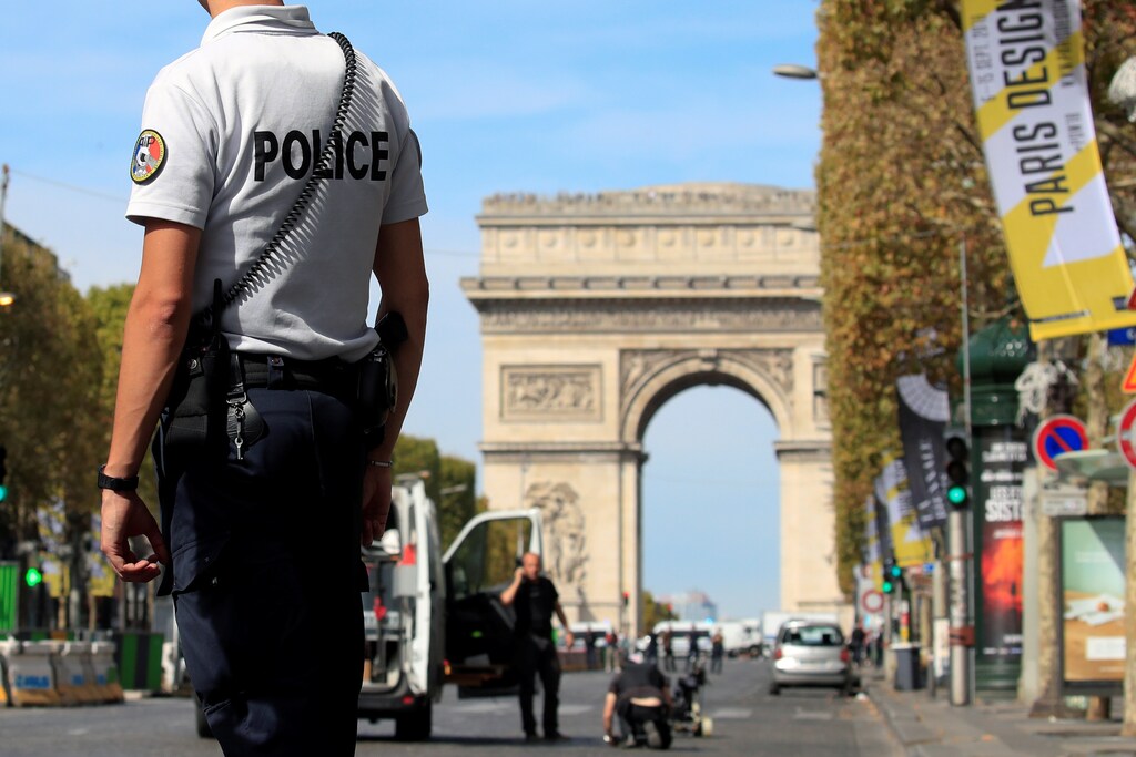 French police stand as Paris police bomb squad inspect a car in Champs Elysees avenue in Paris, France, September 16, 2018. REUTERS/Gonzalo Fuentes - RC1C8FE01740
