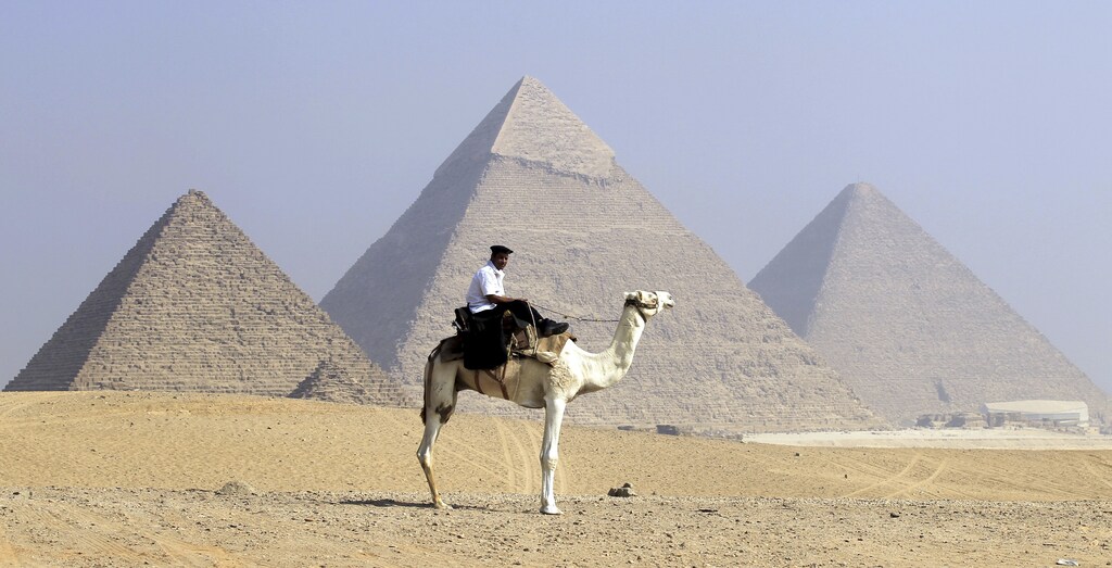 A security officer patrols the Giza Pyramids on his camel in Cairo, October 1, 2012. REUTERS/Mohamed Abd El Ghany (EGYPT - Tags: ANIMALS TRAVEL SOCIETY) - GM1E8A11U4901