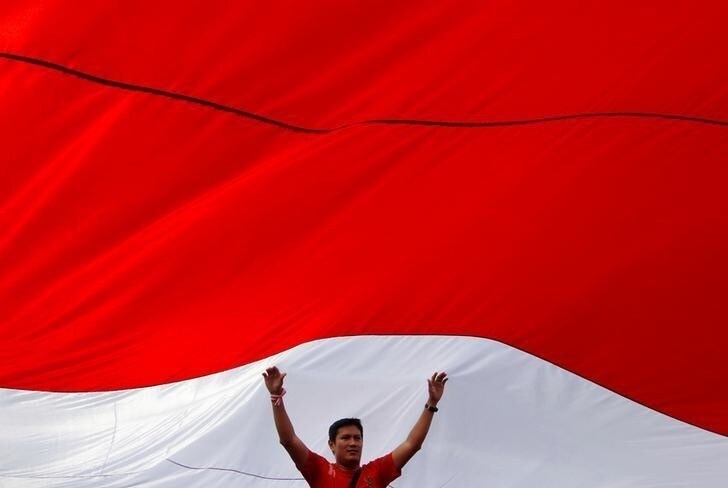 A man touches a large Indonesian flag as he takes part in a rally against what organisers see as growing racial and religious intolerance in the world's largest Muslim-majority country, in Jakarta, Indonesia November 19, 2016. REUTERS/Iqro Rinaldi TPX IMAGES OF THE DAY