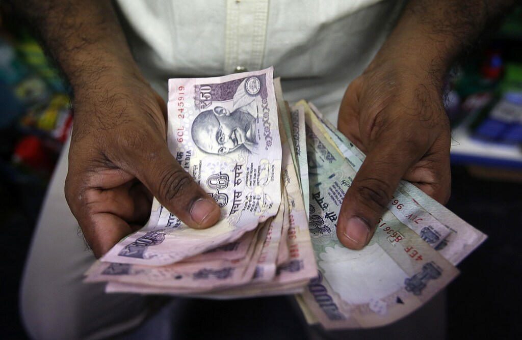A private money trader counts Indian Rupee currency notes at a shop in Mumbai August 1, 2013.