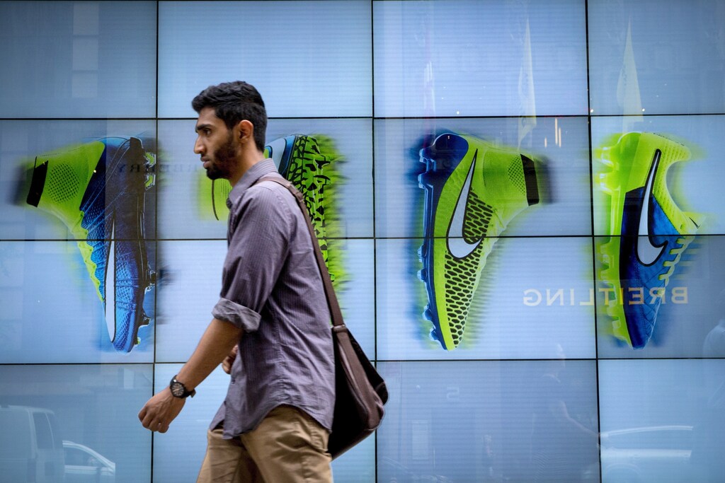 A man passes by the Niketown store in midtown Manhattan in New York June 25, 2015. Nike Inc, the world's largest footwear maker, reported a better-than-expected profit for the eighth quarter in a row as it sold more high margin basketball shoes and apparel at higher prices.