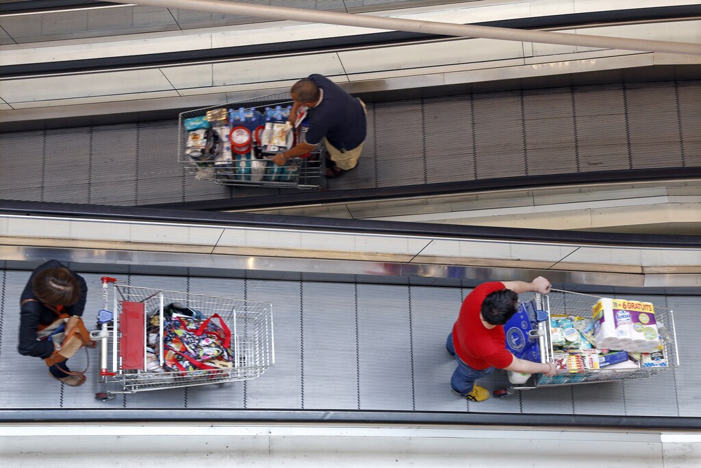 Customers push shopping trolleys on an escalator