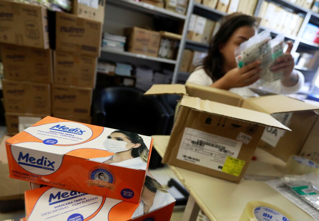 An employee packs medical masks, that are part of personal protection and survival equipment kits ordered by customers preparing against novel coronavirus, at a centre of an express delivery company in Porto Alegre, Brazil February 28, 2020. REUTERS/Diego Vara - RC2T9F9ZY8W4