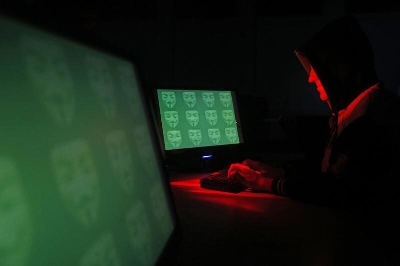 Man poses in front of on a display showing the word 'cyber' in binary code, in this picture illustration taken in Zenica December 27, 2014. A previously undisclosed hacking campaign against military targets in Israel and Europe is probably backed by a country that misused security-testing software to cover its tracks and enhance its capability, researchers said. Picture taken December 27, 2014.