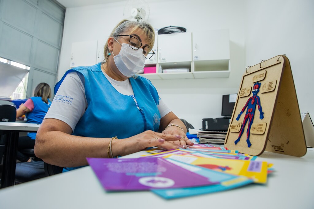 A nurse sorts out pamphlets at a desk: Cardiovascular disease is one of the world’s biggest killers.