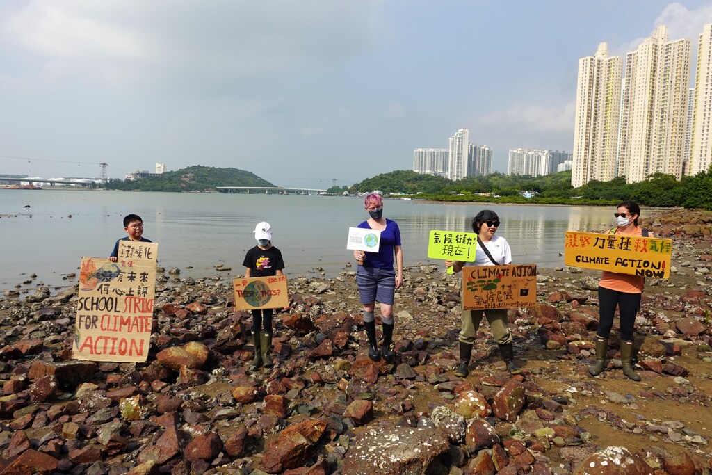Lance Lau, 11, Elise Hon, 11, Rose Netherton, 36, and other climate activists hold placards as they pose for pictures during a climate strike and a beach clean-up at San Tau Beach on Lantau island in Hong Kong, China September 25, 2020. REUTERS/Joyce Zhou - RC2P5J9CIIMS
