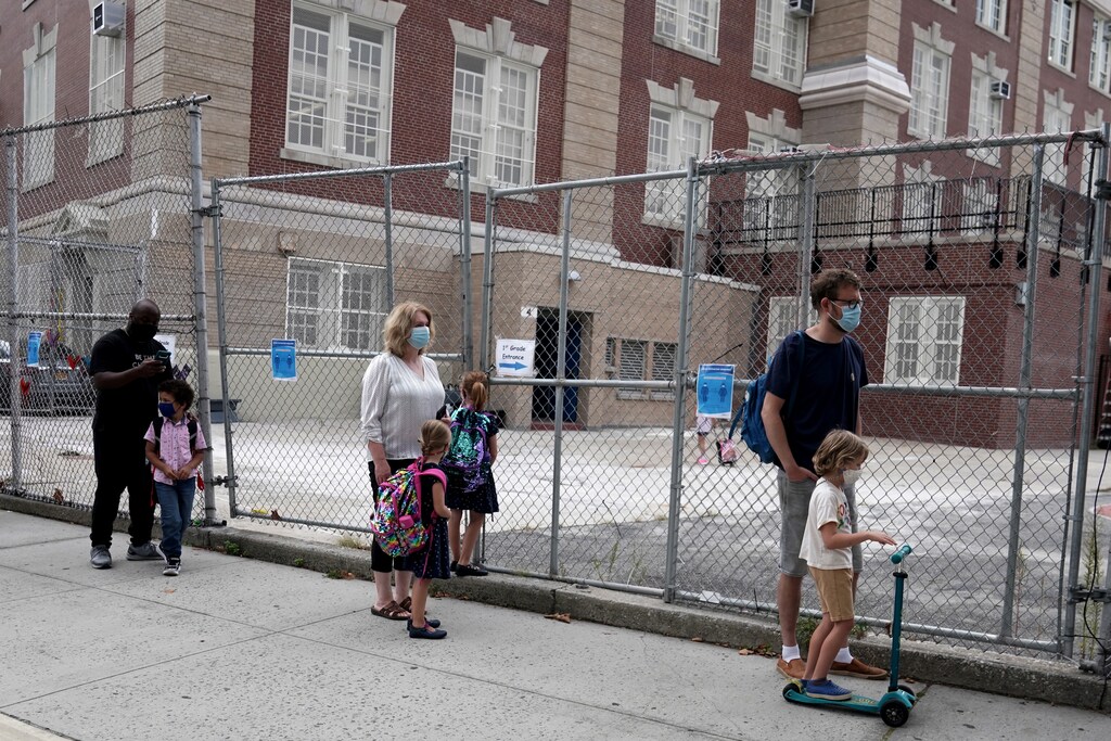 Parents line up with their children before the first day of grade 1 at P.S. 130 in the Brooklyn borough of New York City, New York, U.S., September 29, 2020. REUTERS/Carlo Allegri - RC2E8J9V7UOC