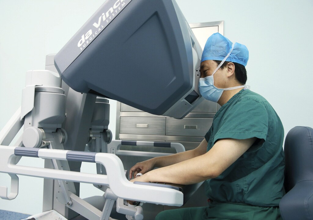 A doctor operates on a patient with a surgical robot in Hefei, Anhui province September 24, 2014. Technology is playing a growing role as Beijing overhauls a healthcare management sector blighted by chaotic patient data, underfunded rural health centres, overburdened city hospitals and a nationwide shortage of doctors. Government-supported programs are looking to leverage specialised software and communication equipment to get the most out of in-demand doctors and specialists at leading hospitals. China's healthcare management sector is growing at close to 40 percent a year and will hit $38 billion in the next five years, according to local consultancy Raisewin International. Picture taken September 24, 2014. To match CHINA-HEALTHCARE/DIGITAL. REUTERS/Stringer (CHINA - Tags: HEALTH SCIENCE TECHNOLOGY SOCIETY BUSINESS) CHINA OUT. NO COMMERCIAL OR EDITORIAL SALES IN CHINA - GM1EAAF0EWJ01