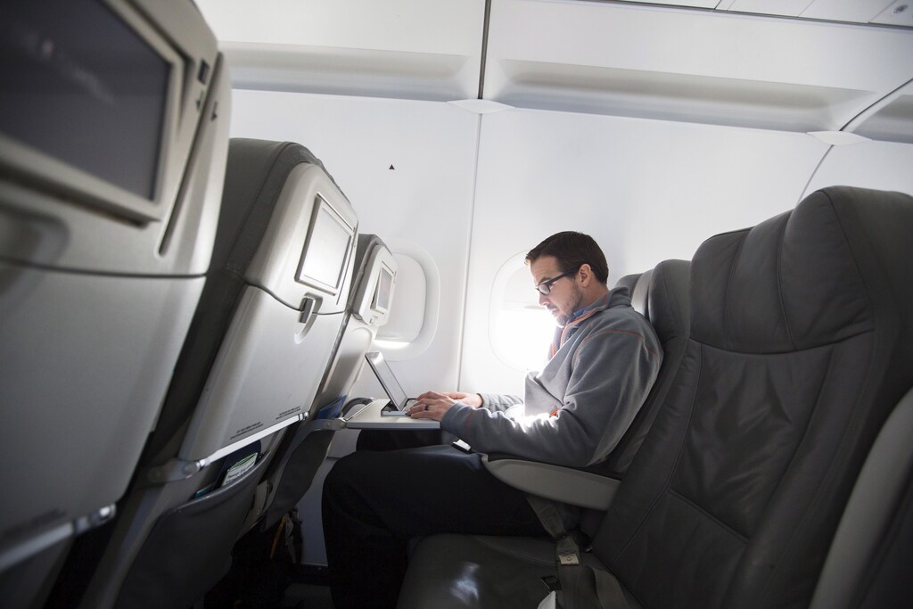 A man uses his laptop to test a new high speed inflight Internet service named Fli-Fi while on a special JetBlue media flight out of John F. Kennedy International Airport in New York in this December 11, 2013 file picture. REUTERS/Lucas Jackson/Files - RTX29JCK