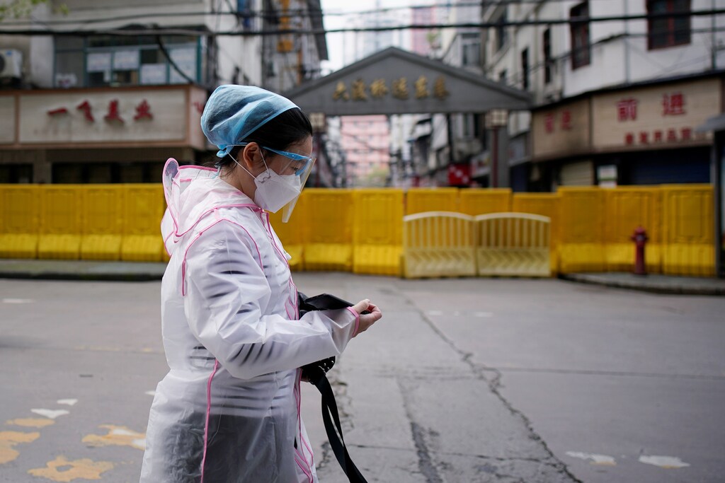 Una mujer con una máscara facial camina en una zona residencial bloqueada por barreras en Wuhan, provincia de Hubei, el epicentro del brote de la enfermedad coronavirus de China (COVID-19), el 3 de abril de 2020.