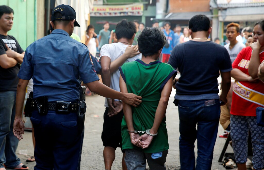 Policemen escort two men who were detained because of pending criminal court cases, during an anti-drugs operation in Mandaluyong, Metro Manila in the Philippines, November 10, 2016. REUTERS/Erik De Castro - RTX2SZHM