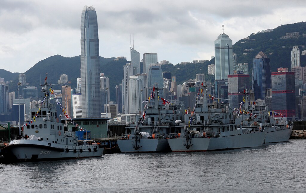 People's Liberation Army military vessels station at a naval base, with the financial Central district seen at background, during an open day celebrating the 19th anniversary of Hong Kong's handover to Chinese sovereignty from British rule, in Hong Kong July 1, 2016. REUTERS/Bobby Yip - RTX2J5TL