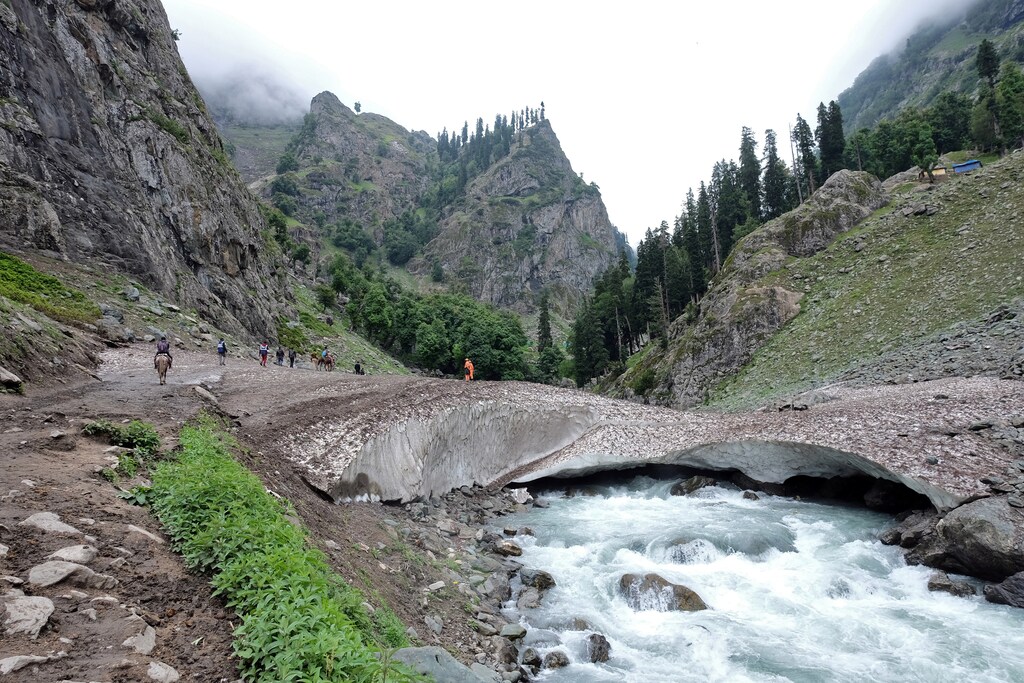 Hindu pilgrims trek through mountains to reach the holy Amarnath cave shrine, where they worship an ice stalagmite that Hindus believe to be the symbol of Lord Shiva, near Pahalgam in the Kashmir region, July 27, 2019. Picture taken July 27, 2019. REUTERS/Alasdair Pal - RC1E69067AD0