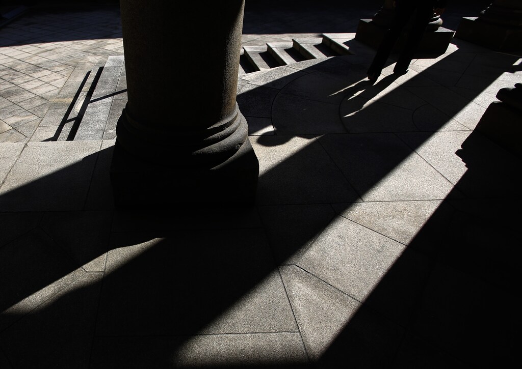 The shadow of a woman is cast at the Old Building of Bank of Japan's head office in Tokyo October 29, 2014. With just five months left before Governor Haruhiko Kuroda's self-imposed deadline for banishing deflation, the Bank of Japan is preparing for failure, and the first casualty could be its facade of board unity. Picture taken October 29, 2014. To match Insight JAPAN-ECONOMY/ REUTERS/Toru Hanai (JAPAN - Tags: BUSINESS TPX IMAGES OF THE DAY) - RTR4C3KX