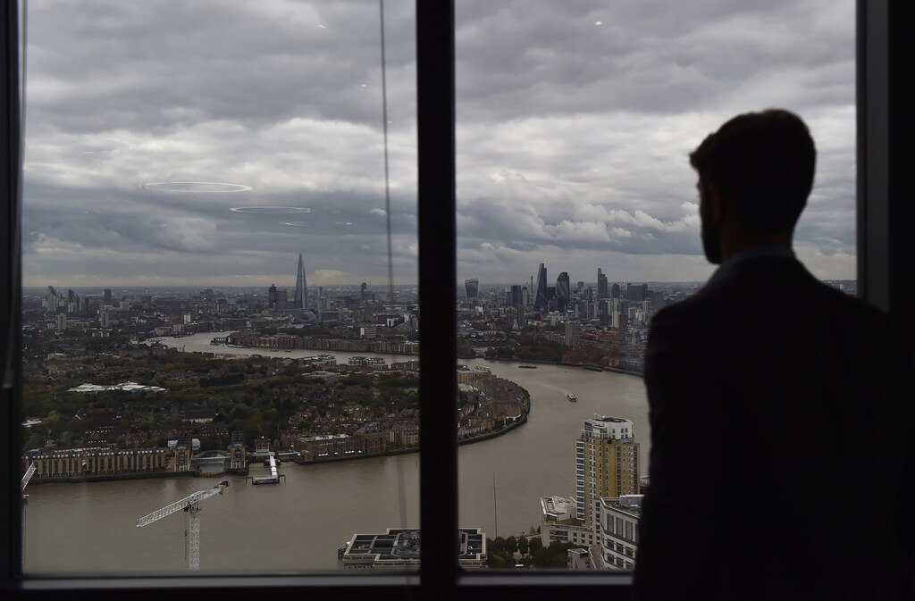A member of staff poses at the One Canada Square skyscraper at Canary Wharf in London, Britain, October 19, 2016. REUTERS/Hannah McKay - RTX2PNWW