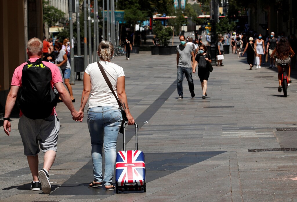 People wear protective face masks as they make their way, amid the coronavirus disease (COVID-19) outbreak, in Barcelona, Spain July 27, 2020. REUTERS/Albert Gea - RC2M1I90ELNM