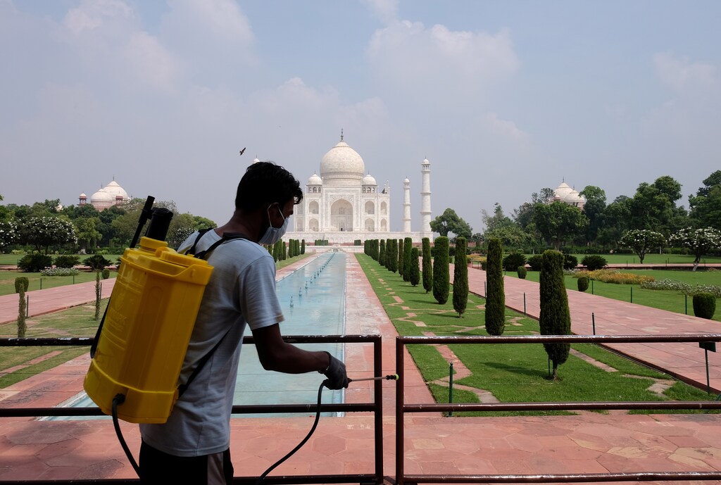 A man sanitizes railings in the premises of Taj Mahal after authorities reopened the monument to visitors, amidst the coronavirus disease (COVID-19) outbreak, in Agra, India, September 21, 2020. REUTERS/Alasdair Pal - RC2U2J9V4ERK