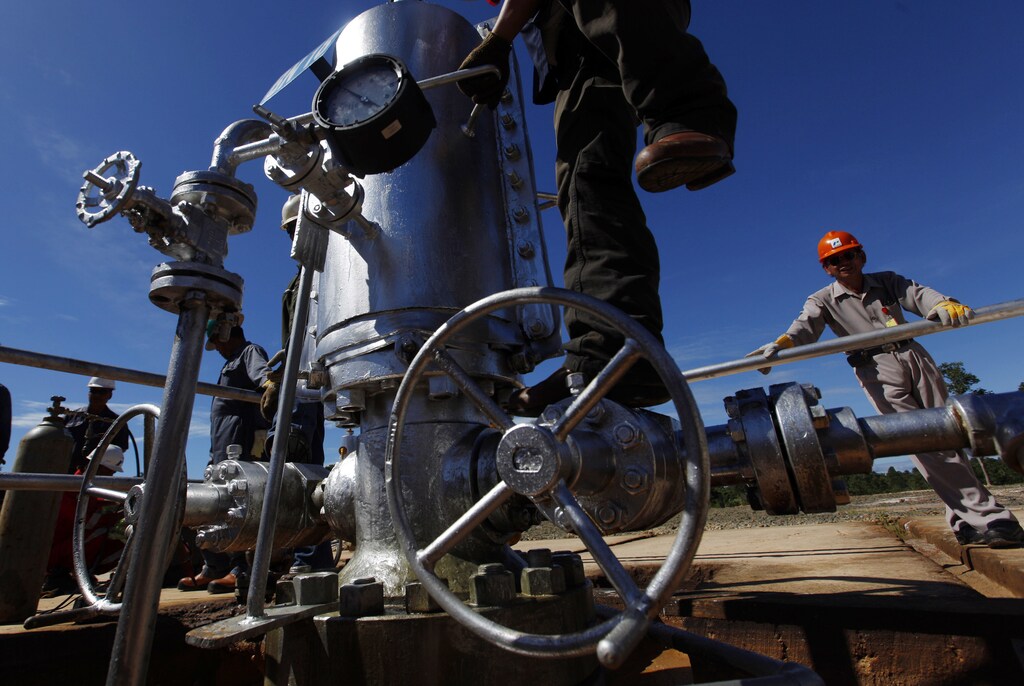 A PT Pertamina worker climbs on a gauge at a crude oil well on Bunyu island, Indonesia's East Kalimantan province February 8, 2011. Indonesian state energy firm Pertamina plans to spend $1 billion in 2011 for acquisitions of oil and gas blocks, as the country seeks to boost declining production. Pertamina has said it expects crude and condensate production of 132,000 barrels per day for this year, up just 1 percent from last year, though the former OPEC member country has often missed production targets because of declining output at ageing fields. REUTERS/Beawiharta (INDONESIA - Tags: ENERGY BUSINESS) - GM1E7281LK501