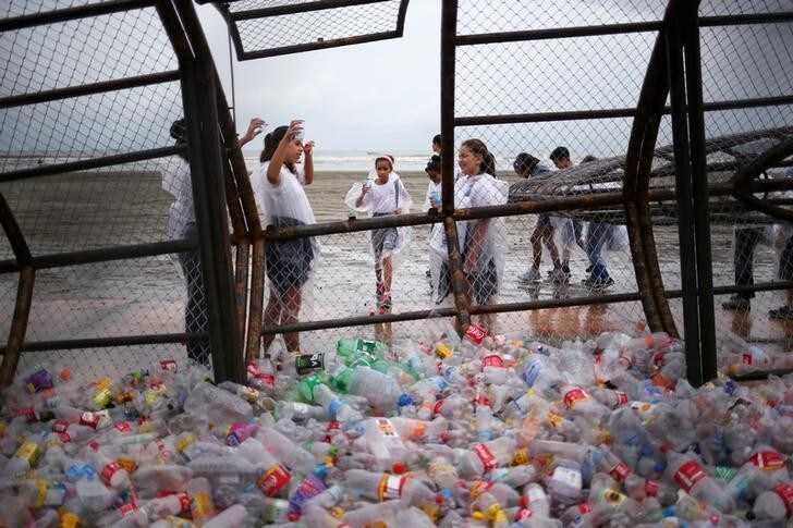 Students put plastic cups inside a whale shark sculpture, designed to store collected recyclable waste from the beach, inaugurated during a World Water Day in Santos, Brazil March 22, 2019. REUTERS/Amanda Perobelli