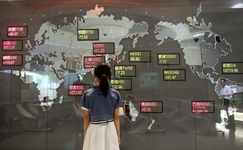 A girl looks at a board showing global stock indices at the Taiwan Stock Exchange in Taipei August 11, 2011. REUTERS/Pichi Chuang (TAIWAN - Tags: BUSINESS IMAGES OF THE DAY) - GM1E78B1BWI01