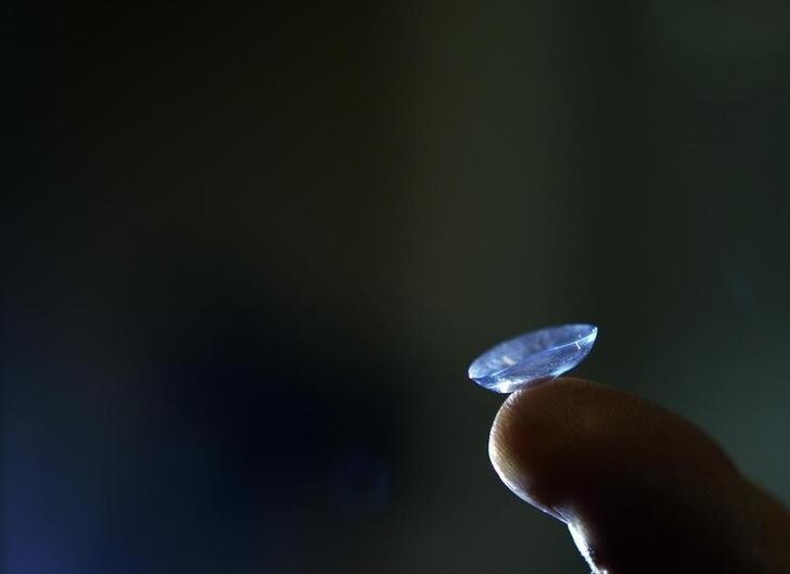 Dr. Alan Titelbaum from the Eye Associates of Somerville, holds up a contact lens at his practice in Somerville, Massachusetts June 10, 2008. While a U.S. Food and Drug Administration (FDA) advisory panel is meeting June 10 to discuss the safety of contact lens care products following the contamination of some Bausch & Lomb products in 2006, Dr. Titelbaum has long advised his patients to rub or dust their contact lenses to clean them, even when using so-called "no rub" solutions. REUTERS/Brian Snyder (UNITED STATES)