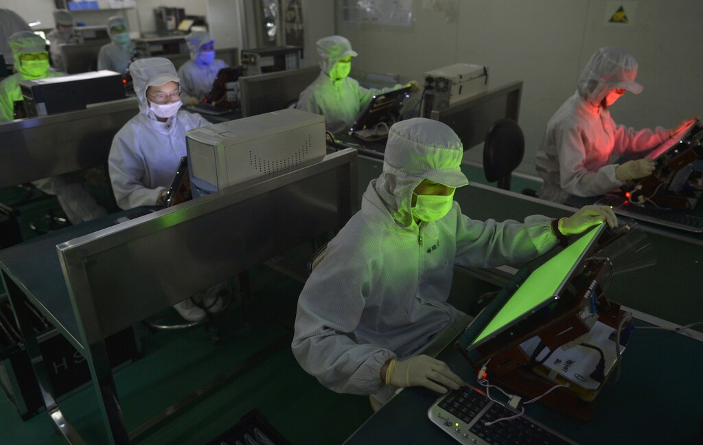 Employees work inside a LCD factory in Wuhan, Hubei province, May 8, 2013. Chinese flat screen makers, once dismissed as second-class players in the global LCD market, are drawing envious looks from big names such as LG Display Co Ltd and Samsung. While the Korean giants were busy developing next-generation organic light emitting diode (OLED) TVs, little-known Chinese companies have started selling a type of display that are sharper than the standard LCD and cheaper than OLED. Picture taken May 8, 2013. REUTERS/China Daily (CHINA - Tags: BUSINESS) CHINA OUT. NO COMMERCIAL OR EDITORIAL SALES IN CHINA - GM1E99H0ERL01