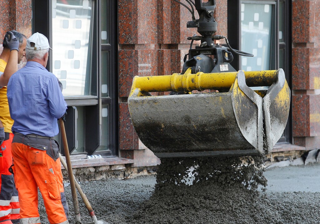 Workers watch concrete being poured to build a pavement in central Vienna, Austria, May 23, 2017. REUTERS/Heinz-Peter Bader - RTX377DO