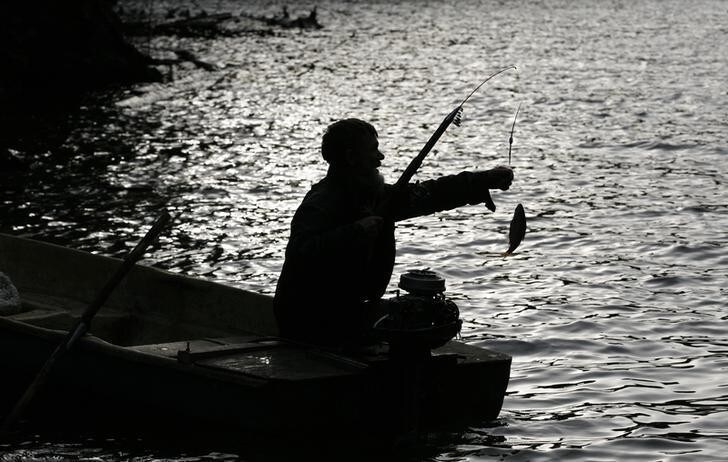 Former bargeman Viktor, 57, who refused to give his last name, fishes on the Yenisei River, some 55 km (34 miles) south of Russia's Siberian city of Krasnoyarsk, October 17, 2013. A decade ago, Viktor decided to lead the life of a hermit, and settled in a wooden hut in this secluded forest area hidden from civilisation. He reads the Bible, and survives mainly on fish, berries, mushrooms and other food he can find. Picture taken October 17, 2013. REUTERS/Ilya Naymushin (RUSSIA - Tags: ENVIRONMENT SOCIETY ANIMALS FOOD)
