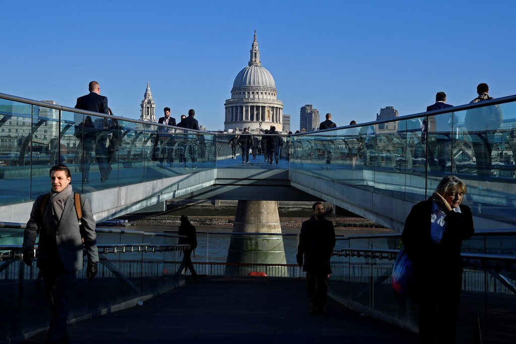 Workers are seen crossing the Millennium Bridge, with St Paul's Cathedral seen behind during the morning rush hour in London, Britain, September 25, 2018. Picture taken September 25, 2018. To match Exclusive BRITAIN-EU/CITY REUTERS/Toby Melville - RC13569F4470