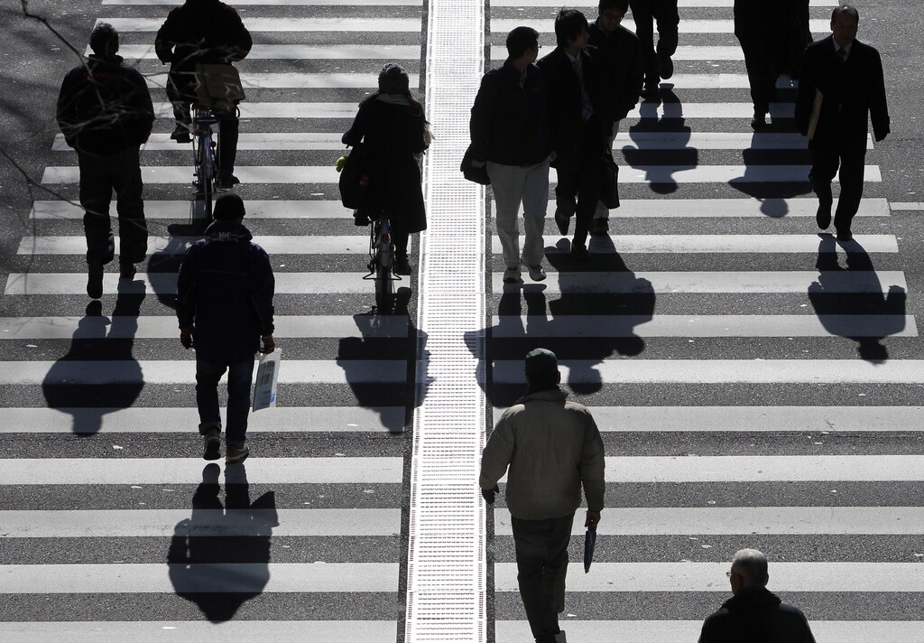 People walk on a crosswalk in Tokyo January 11, 2011. Japan's index of coincident economic indicators rose a preliminary 1.4 points in November from the previous month, the Cabinet Office said on Tuesday, up for the first time in three months. REUTERS/Yuriko Nakao (JAPAN - Tags: EMPLOYMENT BUSINESS) - GM1E71B15WJ01