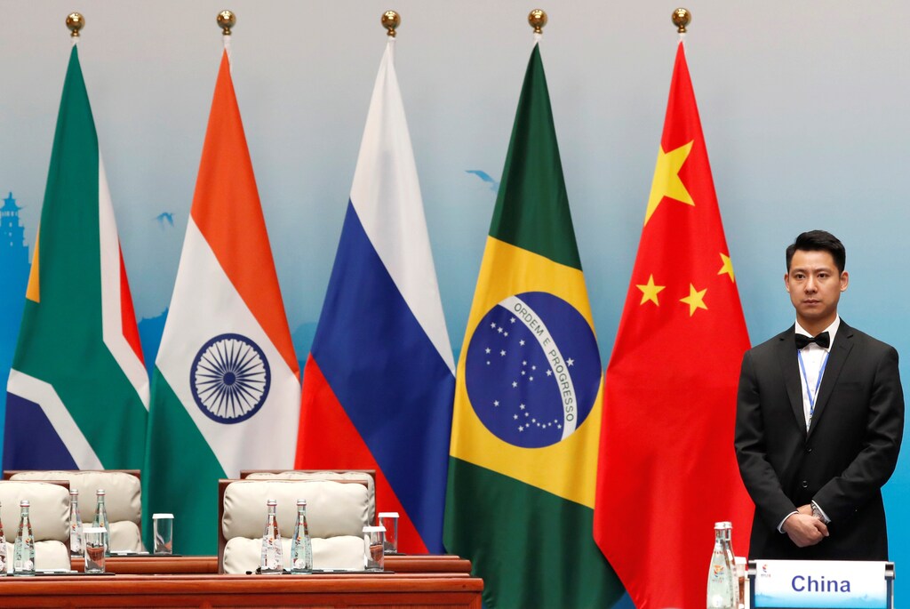 An attendant is stands next to South African, Indian, Russian, Brazilian and Chinese flags during a plenary session of BRICS Summit, in Xiamen, China September 4, 2017. REUTERS/Tyrone Siu - RC171C446C10