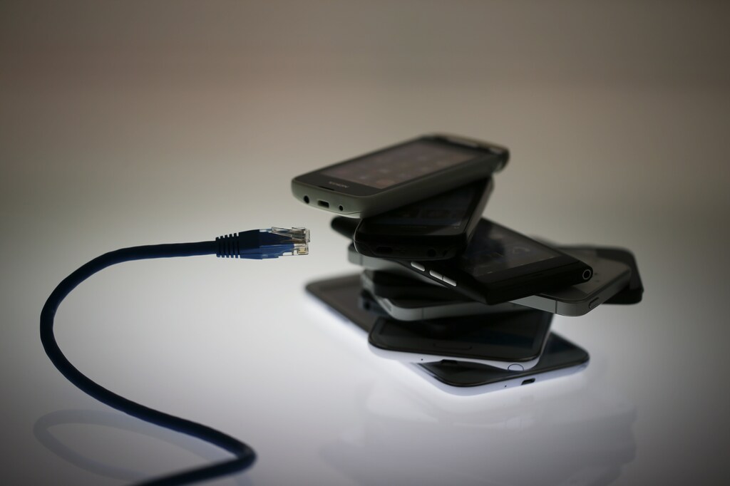 An illustration picture shows a network cable next to a pack of smartphones in Berlin, June 7, 2013. The debate over whether the U.S. government is violating citizens' privacy rights while trying to protect them from terrorism escalated dramatically on Thursday amid reports that authorities have collected data on millions of phone users and tapped into servers at nine internet companies. REUTERS/Pawel Kopczynski (GERMANY - Tags: POLITICS SOCIETY BUSINESS) - BM2E967131Y01