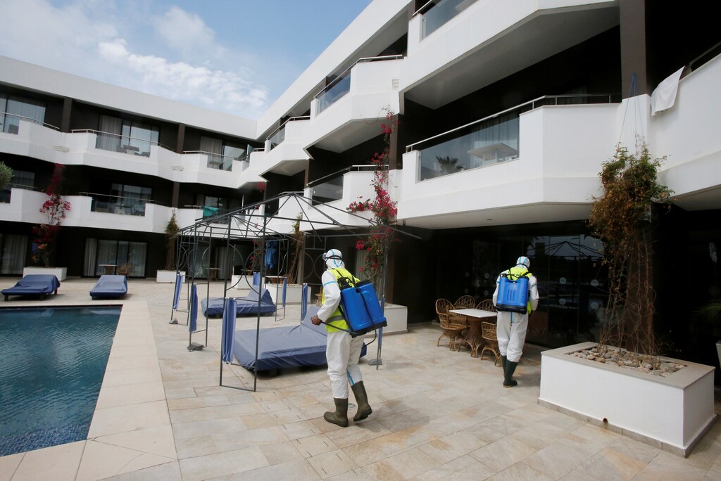 Trabajadores con trajes protectores desinfectan el hotel Dawliz, que se utiliza como lugar de refugio temporal para todo tipo de material médico con el fin de aumentar el distanciamiento social durante el brote de la enfermedad coronavirus (COVID-19) en Sale, Marruecos. 24 de abril de 2020.