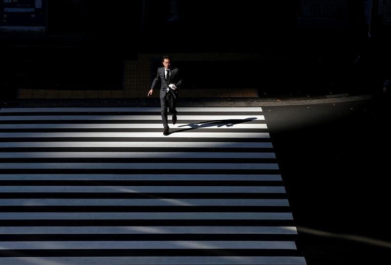 A businessman crosses a road at Tokyo's business district, Japan January 20, 2016. REUTERS/Toru Hanai/File Photo - S1AETLCQKAAA