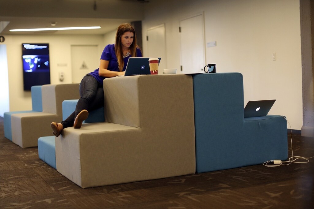 Twitter employee Amber Costa works on a computer at Twitter headquarters in San Francisco, California October 4, 2013. Twitter Inc, racing toward the largest Silicon Valley IPO since Facebook Inc's 2012 coming-out party, hopes to woo investors with rip-roaring revenue growth despite having posted big losses over the past three years. The eight-year-old online messaging service gave potential investors their first glance at its financials on Thursday when it publicly filed its IPO documents, setting the stage for one of the most-anticipated debuts in over a year. REUTERS/Robert Galbraith (UNITED STATES - Tags: SCIENCE TECHNOLOGY BUSINESS) - RTR3FLSH