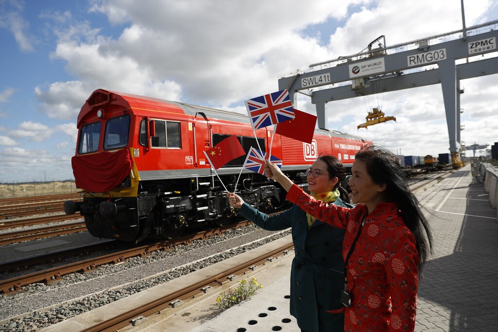 Chinese women wave flags at the official ceremony to mark the departure of the first UK to China export train, laden with containers of British goods, from the DP World London Gateway, Stanford-le-Hope, Britain April 10, 2017. REUTERS/Peter Nicholls - LR1ED4A0PDTXT