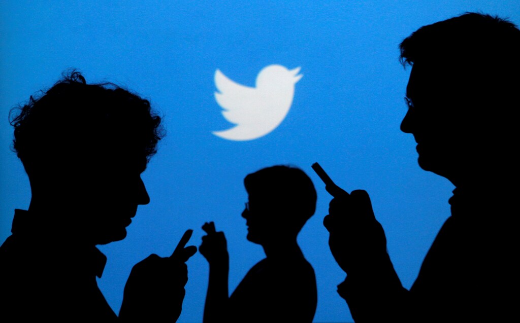 FILE PHOTO -- People holding mobile phones are silhouetted against a backdrop projected with the Twitter logo in this illustration picture taken in Warsaw September 27, 2013. REUTERS/Kacper Pempel/Illustration/File Photo - RTSR1PD