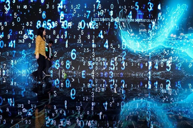 People walks in front of a screen at the World Internet Conference (WIC) in Wuzhen, Zhejiang province, China, October 20, 2019. REUTERS/Aly Song - RC118EEFEBA0