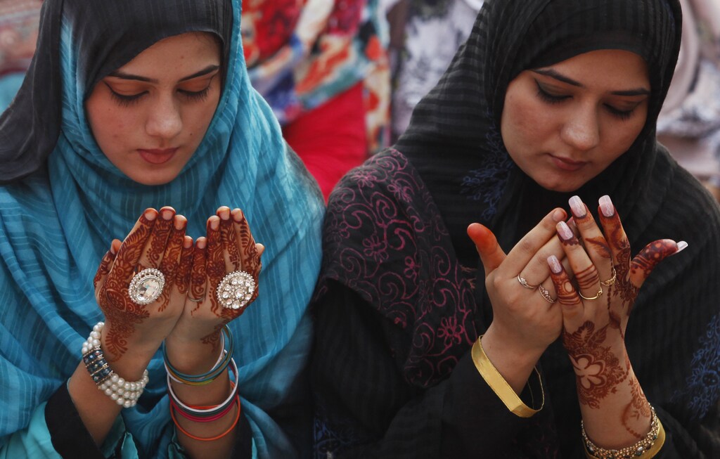 Muslim women attend a mass prayer for Eid al-Adha in Lahore October 6, 2014. Muslims across the world celebrate the annual festival of Eid al-Adha, which marks the end of the annual Haj pilgrimage, by slaughtering goats, sheep, cows and camels in commemoration of the Prophet Abraham's readiness to sacrifice his son to show obedience to Allah. Eid al-Adha in Pakistan falls on October 6. REUTERS/Mohsin Raza (PAKISTAN - Tags: RELIGION SOCIETY) - RTR492BR