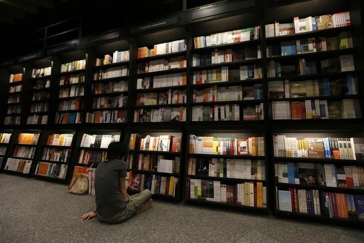A customer sits in front of bookshelves at Eslite bookstore in Hong Kong August 10, 2012. Taiwanese bookstore Eslite, one of the largest retail bookstore chains in Taiwan, opened their first overseas store on Friday. The three-storey-high shop, which stretches to 41,000 square feet, is the city's largest bookstore. REUTERS/Tyrone Siu (CHINA - Tags: SOCIETY BUSINESS)