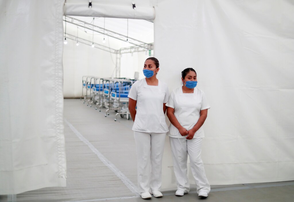 Two nurses wearing protective masks pose inside the new immediate response mobile hospital with 50 intensive care beds against the outbreak of coronavirus disease (COVID-19) in Pachuca, Hidalgo, Mexico, March 19, 2020. Picture taken March 18, 2020. REUTERS/Henry Romero - RC28NF9J1RS7