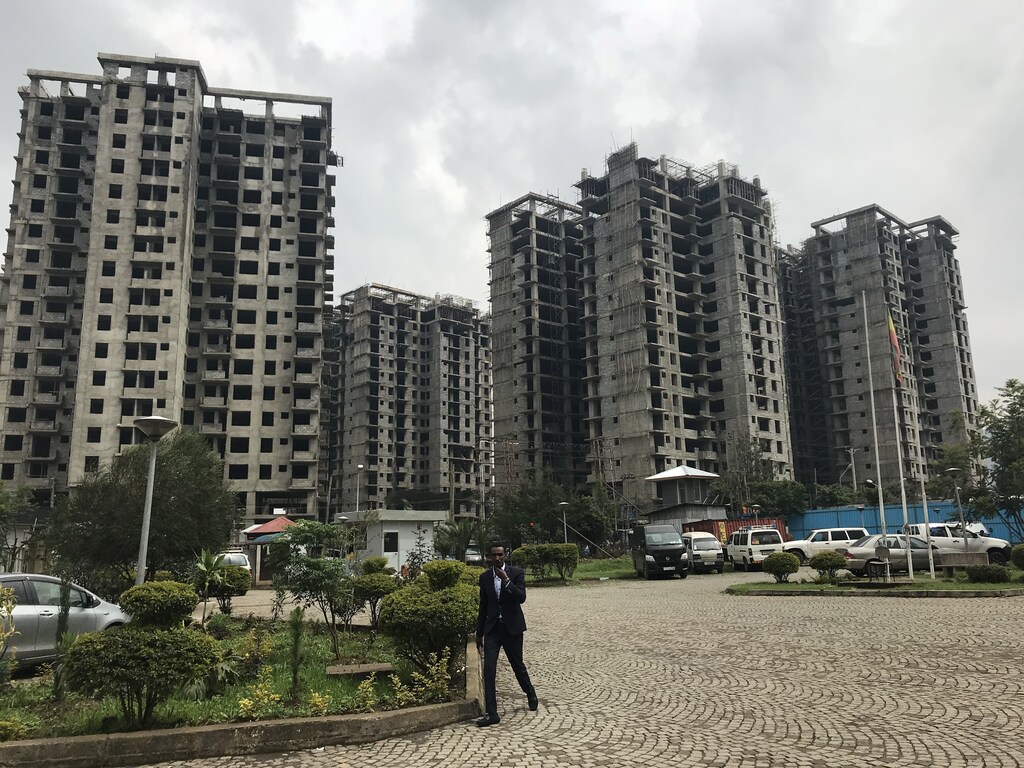 A man walks past a construction site in Addis Ababa, Ethiopia, July 24 2018. Picture taken July 24 2018.REUTERS/Maggie Fick - RC170231F590
