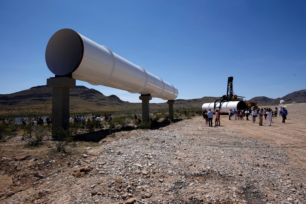 Journalists and guests look over tubes following a propulsion open-air test at Hyperloop One in North Las Vegas, Nevada U.S. May 11, 2016. REUTERS/Steve Marcus - S1BETDMFXPAA