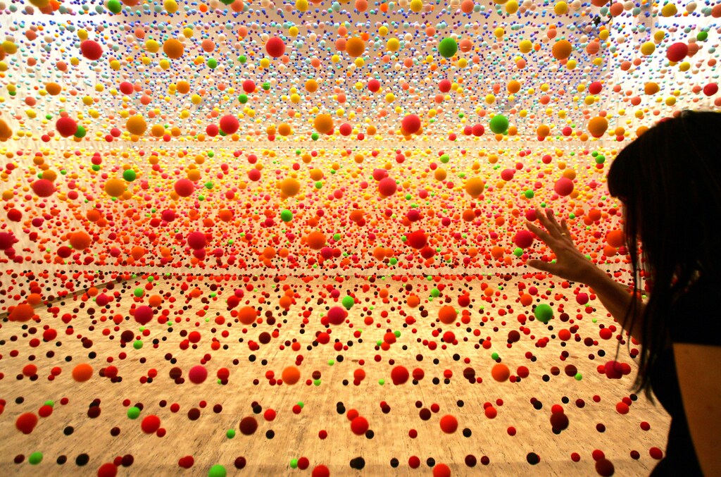 Australian artist Nike Savvas makes final adjustments to her art piece consisting of over 50,000 polystyrene balls at the New South Wales Art Gallery in Sydney August 3, 2006. The sculpture titled "Atomix - Full of Love, Full of Wonder" , vibrates with wind from 10 fans and represents the different "shimmering" colours in a hot, outback landscape. It is part of a sculpture exhibition "Adventures with Form in Space" that will open to the public next week. REUTERS/David Gray (AUSTRALIA) - RTR1G1KV