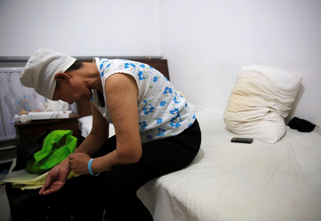 Huang sits on a bed in her room at the accommodation where patients and their family members stay while seeking medical treatment in Beijing, China, June 22, 2016. Huang, who suffers from rectal cancer, came from Inner Mongolia to seek treatment at a specialist hospital in Beijing. REUTERS/Kim Kyung-Hoon SEARCH "HOSPITAL ACCOMMODATION" FOR THIS STORY. SEARCH "WIDER IMAGE" FOR ALL STORIES. - D1BEUEBQCLAA