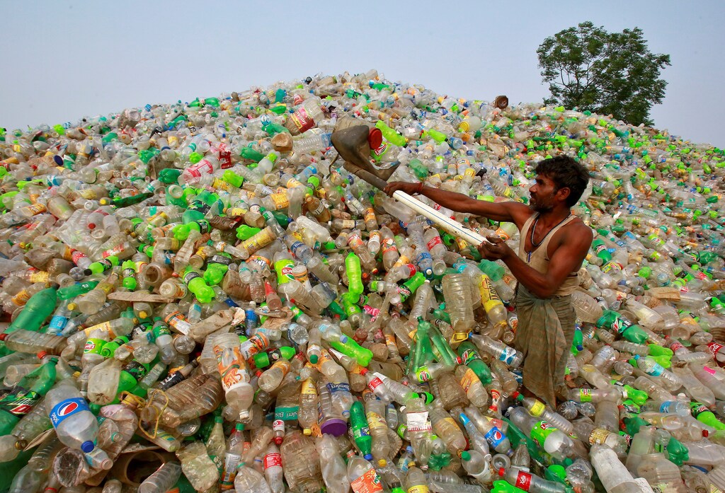 A man makes a heap of plastic bottles at a junkyard on World Environment Day in Chandigarh, India, June 5, 2018. REUTERS/Ajay Verma - RC1DE0385630